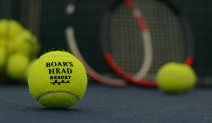 A Tennis Ball On A Court With A Racket