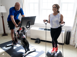 A Woman Standing Next To A Man On A Treadmill