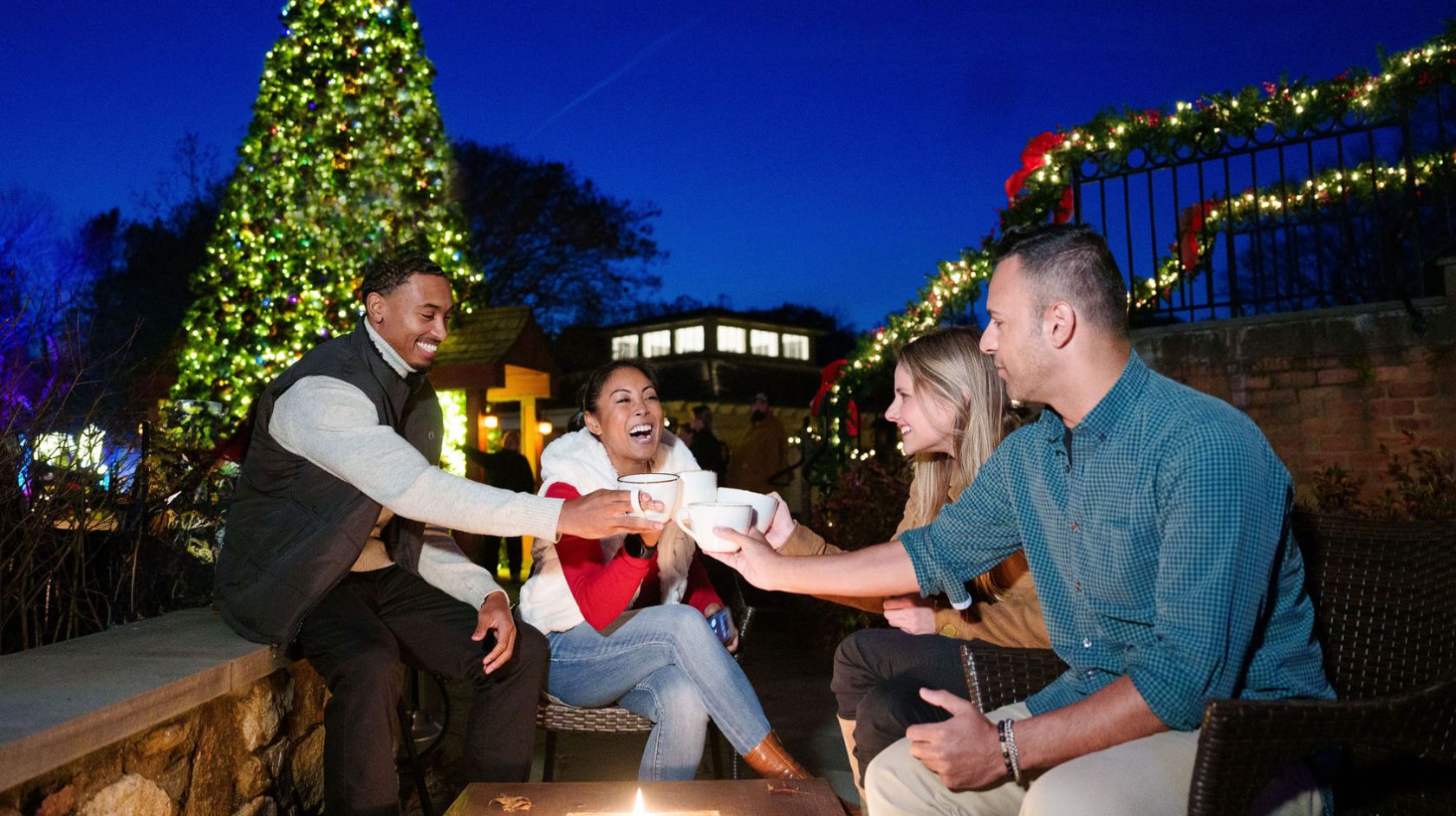 A Group Of People Sitting On A Bench In Front Of A Christmas Tree