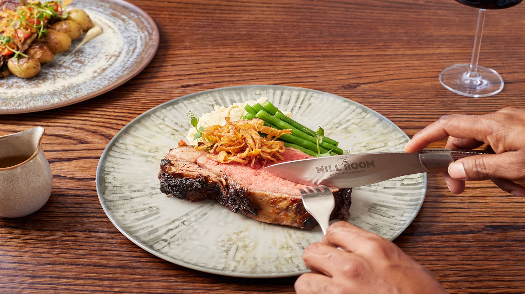 A Person Cutting A Piece Of Meat With A Knife